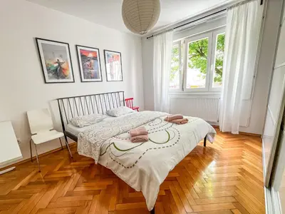 a bedroom with a bed and a wooden floor at Bell Apartment in Bihać