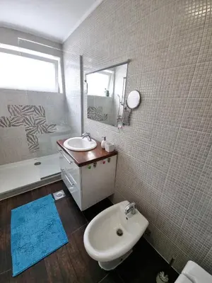 a bathroom with a sink and a toilet and a mirror at Bell Apartment in Bihać