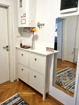 a white dresser with a vase on it in a room at Bell Apartment in Bihać