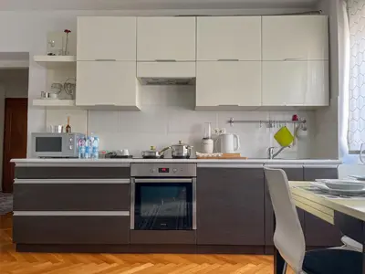 a kitchen with white cabinets and a stove top oven at Bell Apartment in Bihać