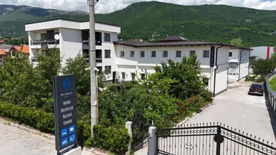 a white building with a sign in front of it at Hotel Residence Travnik in Travnik