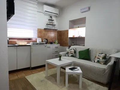 a living room with a couch and a table in a kitchen at Apartman Maric in Drvar
