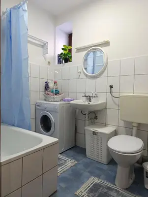a bathroom with a washing machine and a sink at Apartman Maric in Drvar