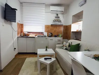 a living room with a couch and a kitchen at Apartman Maric in Drvar