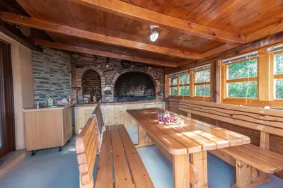 a kitchen with wooden tables and benches in a cabin at Delta apartments in Bihać