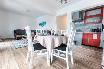 a kitchen and dining room with a table and chairs at Delta apartments in Bihać