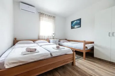 a bedroom with two beds and a window at Delta apartments in Bihać