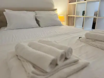 a white bed with towels on top of it at River Apartment in Banja Luka