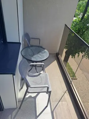a balcony with a table and chairs on a building at River Apartment in Banja Luka