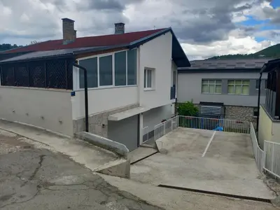 a white house with a driveway in front of it at Apartman CENTAR 1 in Jajce