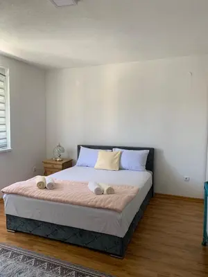 a bedroom with a large bed with two pillows at Apartmani CENTAR in Jajce