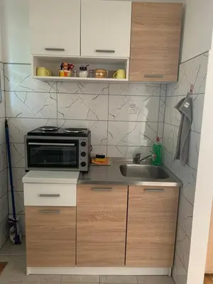 a small kitchen with a sink and a microwave at Apartmani CENTAR in Jajce