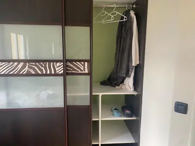 a closet with wooden doors and shelves with clothes at Bolek mansion in Banja Luka