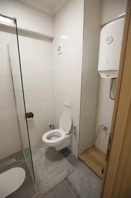 a bathroom with a toilet and a glass shower at Apartman Hana Fojnica in Fojnica