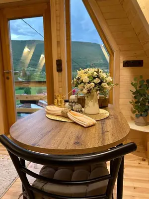 a wooden table with a vase of flowers on it at Dream House Una in Orašac