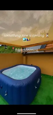 a sign that reads something new is coming next to a hot tub at Dream House Una in Orašac