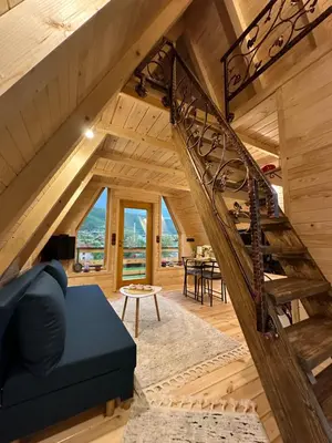 a staircase in a wooden house with a blue couch at Dream House Una in Orašac