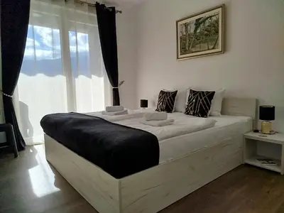 a bedroom with a large white bed with a window at Pinocchio in Bihać