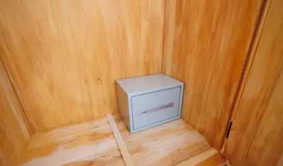 a small white cabinet in a room with wooden walls at Guest House Fiona in Bihać