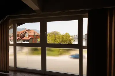 an open window with a view of a house at Guest House Fiona in Bihać