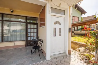 a patio with a white door and a stool at Guest House Fiona in Bihać