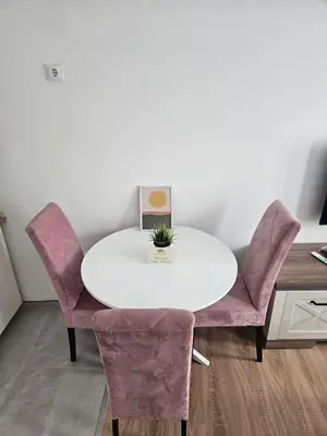 a white table with purple chairs in a room at Mrakovica 1935 in Prijedor