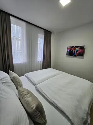 a bedroom with two beds and a tv on the wall at Mrakovica 1935 in Prijedor