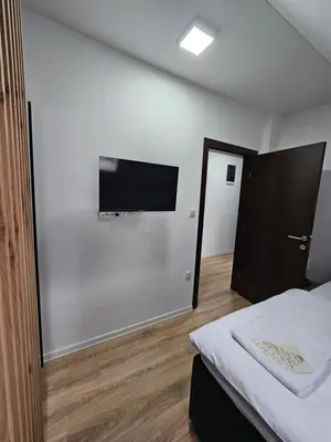 a bedroom with a bed and a flat screen tv on the wall at Mrakovica 1935 in Prijedor
