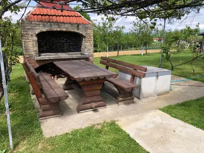 a picnic table and a bench next to a brick oven at Apartment Vuleta Deluxe Extra groß in Prijedor
