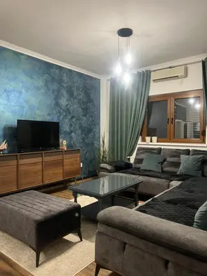a living room with a couch and a tv at Apartman Elma in Bihać