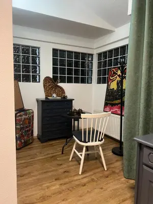 a room with a chair and a black dresser at Apartman Elma in Bihać