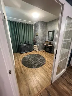 a living room with a green curtain and a table at Apartman Elma in Bihać
