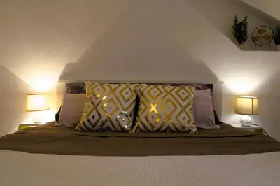 a bedroom with a bed with pillows and two lamps at Svila Apartmani in Bihać
