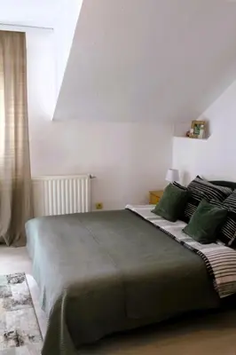 a bedroom with a large bed with green pillows at Svila Apartmani in Bihać