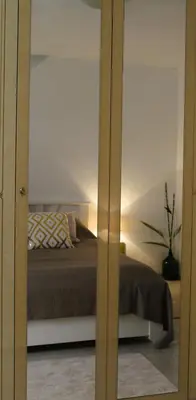 a bedroom with a bed and a mirror at Svila Apartmani in Bihać