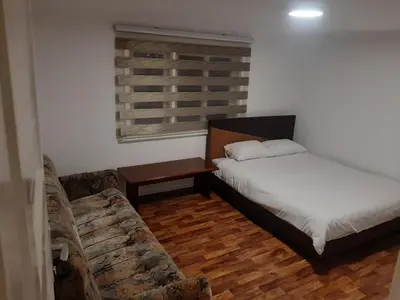 a bedroom with a bed and a couch and a window at Hasan's apartment - holiday house - vikendica - kuća za odmor - apartman in Visoko