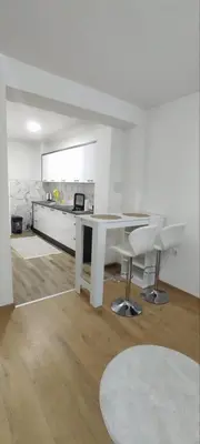 a kitchen with a white table and two white chairs at Apartman Aura in Travnik