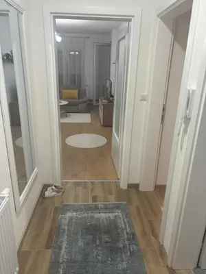 a hallway with a living room with a couch and a rug at Apartman Aura in Travnik