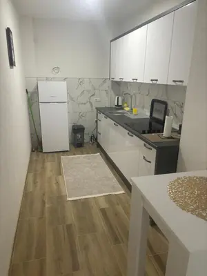 a kitchen with white cabinets and a white refrigerator at Apartman Aura in Travnik