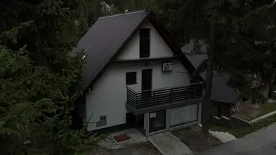 a white house with a black roof at Vila Flora Vlašić in Šišava
