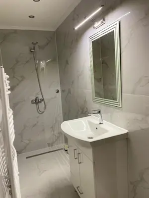a white bathroom with a sink and a shower at Vila Flora Vlašić in Šišava