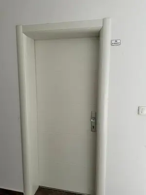 a white elevator door with a sign on it at Studio Apartman Centar 2 in Livno
