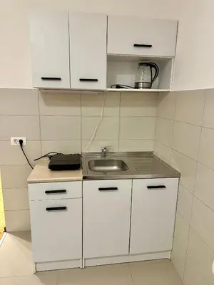 a kitchen with white cabinets and a sink at Studio Apartman Centar 2 in Livno
