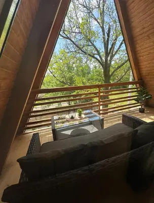 a living room with a large window on a deck at Ammirevole Ravne Oga in Visoko