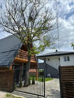 a house with a fence and a tree at Ammirevole Ravne Oga in Visoko