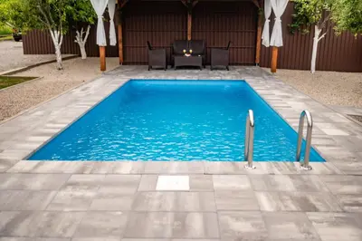 a swimming pool with blue water in a yard at Kuća za odmor Dani in Bihać