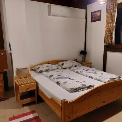 a bedroom with a wooden bed and a chair at Kuća za odmor Dani in Bihać