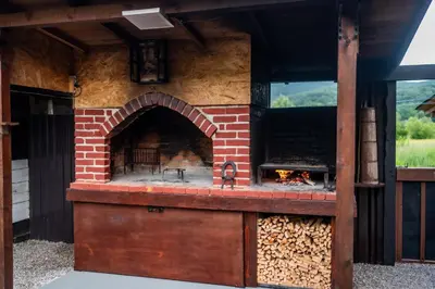 an outdoor brick oven with a pile of fire wood at Kuća za odmor Dani in Bihać