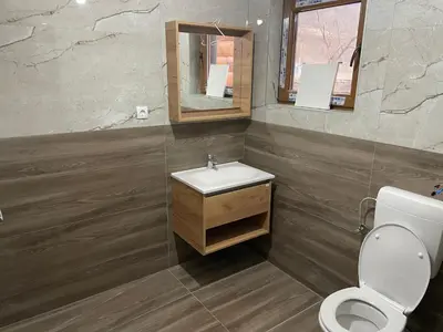 a bathroom with a sink and a toilet and a mirror at Bungalow House - 5 Rooms in Zolaći