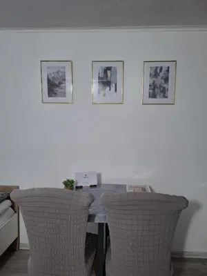 a table with two chairs and a laptop on it at Fly & Stay Apartments in Laktaši